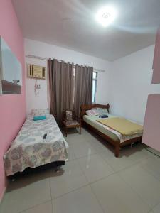 Zimmer mit 2 Betten in einem Zimmer mit Fenster in der Unterkunft Pousada Cantinho da Família in Rio de Janeiro