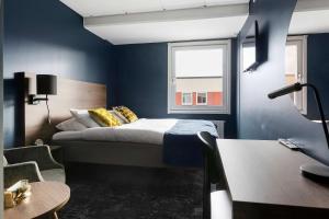 a bedroom with a bed with blue walls and a window at Best Western Nya Star Hotel in Avesta