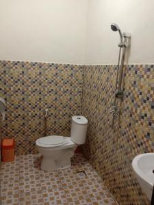 La salle de bains est pourvue de toilettes et d'un lavabo. dans l'établissement Yohana Cottage, à Tual