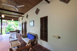 a living room with chairs and a ceiling fan at Ganesha Amed in Amed
