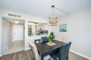 a dining room and kitchen with a black table and chairs at Palma Fabulous Island View Condo in St Petersburg +5 photos
