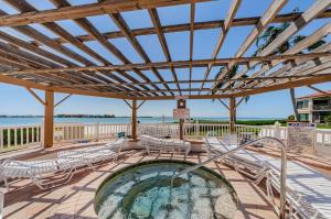 a hot tub on a deck with chairs and tables at Palma Fabulous Island View Condo in St Petersburg