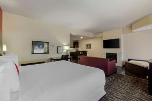 une chambre d'hôtel avec un grand lit et un salon dans l'établissement C Hotel by Carmen's, BW Premier Collection, à Hamilton