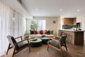ein Wohnzimmer mit einem Sofa, einem Tisch und Stühlen in der Unterkunft Aquarius Apartment 9 in Hawks Nest