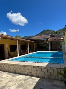 una piscina frente a una casa en Casa Temporada en Ubatuba