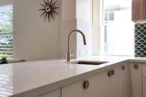 eine Küche mit Spüle und einer Uhr an der Wand in der Unterkunft Aquarius Apartment 9 in Hawks Nest + 15 Fotos