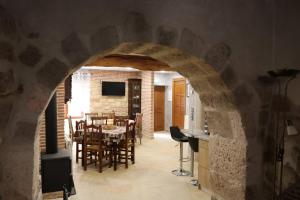 une cuisine et une salle à manger avec une arche en pierre dans l'établissement los arcos y ancasela, à Santa María del Campo