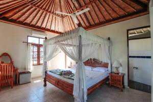 a bedroom with a canopy bed in a room at Ganesha Amed in Amed +113 photos