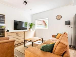 a living room with a couch and a tv at Charming holiday home in Poortugaal with garden in Poortugaal