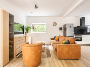 a living room with two couches and a kitchen at Charming holiday home in Poortugaal with garden in Poortugaal