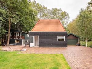 a black house with an orange roof and a yard at Charming holiday home in Poortugaal with garden in Poortugaal