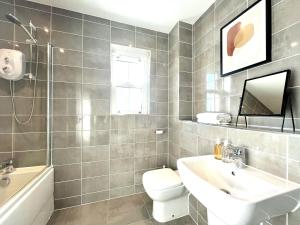 a bathroom with a sink and a toilet and a tub at Lovely 4 doubled bedroomed townhouse in Bicester near to Bicester Village in Bicester +22 photos