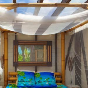 a bedroom with a bed with a canopy and a window at Caraibes insolite in Sainte-Luce
