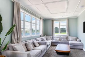 a living room with a white couch and windows at Lake Maraetai Lodge in Mangakino