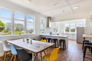 Il comprend une cuisine et une salle à manger avec une table et des chaises en bois. dans l'établissement Lake Maraetai Lodge, à Mangakino