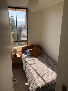 a bedroom with a bed and a large window at Departamento Zapahuira in Arica