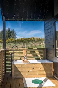 ein Holzbadezimmer mit einem Waschbecken auf einer Terrasse in der Unterkunft The Trossachs Collection in Kepculloch