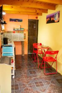 a kitchen with red chairs and a table and a stove at El Kamaruco Chaltén Tiny House de Montaña in El Chalten