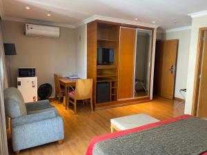 Habitación de hotel con cama, mesa y silla en Apart hotel Barra First, en Río de Janeiro