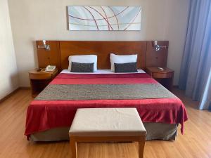 um quarto com uma cama grande e uma colcha vermelha em Apart hotel Barra First no Rio de Janeiro
