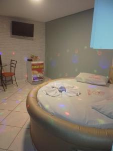 1 dormitorio con 1 cama en una habitación con TV en Hotel l Motel 1001 Noites - Ceilândia, en Brasilia