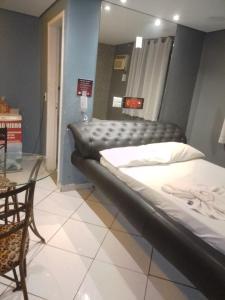 Habitación con 2 camas, mesa y silla en Hotel l Motel 1001 Noites - Ceilândia, en Brasilia