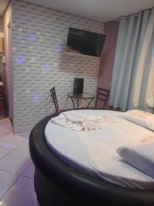 1 cama grande en una habitación con TV en la pared en Hotel l Motel 1001 Noites - Ceilândia, en Brasilia