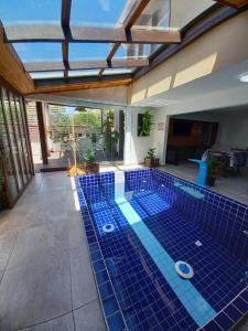 a swimming pool with a blue tiled floor and a pool at Suítes Itaigara a 80 metros da praia do Mariscal in Bombinhas