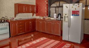 a kitchen with wooden cabinets and a white refrigerator at Huaraz Colonial in Huaraz