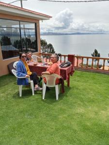 a group of people sitting at a table on the grass at Paqariy lodge in Ocosuyo