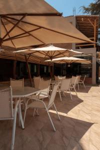 a table and chairs with umbrellas on a patio at Hotel El Huacachinero in Ica