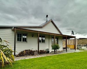 una pequeña casa blanca con un patio de césped en Lexi's Lodge, en Lake Tekapo