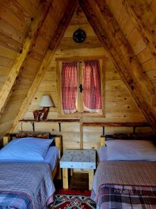 a attic room with two beds and a window at Wolf & Sheep Nature & Adventure in Podgorica