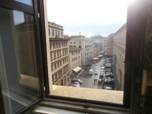 Elle offre une vue sur une rue de la ville depuis sa fenêtre. dans l'établissement Residenza Pantaleo, à Rome