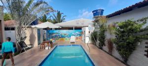 ein Mann, der an einem Swimmingpool in einem Haus vorbeigeht in der Unterkunft Casa com Piscina em Guaratiba in Prado