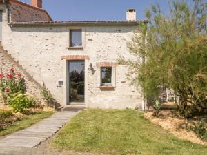 a white brick house with a door and a yard at Gîte Le Loroux-Bottereau, 4 pièces, 6 personnes - FR-1-306-800 in Le Loroux-Bottereau