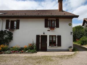 uma casa branca com flores à frente em Gîte Le Val-d'Ajol, 5 pièces, 10 personnes - FR-1-589-139 em Le Val-dʼAjol