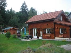 a log cabin with a picnic table in the yard at Chalet en bois avec jardin, proche ski et randonnée, équipé pour 8 pers. à Vagney, Vosges - FR-1-589-283 in Vagney