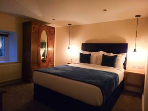 a bedroom with a large bed with two lights on it at Top Hill Farm Cottage in Sheffield