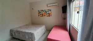 ein kleines Zimmer mit einem Bett und einem Fenster in der Unterkunft Casa com Piscina em Guaratiba in Prado + 44 Fotos