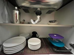 eine Küche mit weißen Tellern auf einem Regal in der Unterkunft NU01- NOVO | 2 Quartos | Churrasqueira | Garagem in Balneário Camboriú