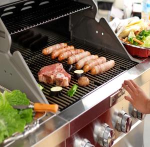 a grill with sausages meat and vegetables on it at オーシャンリゾートshimaoドリームbeach in Himi