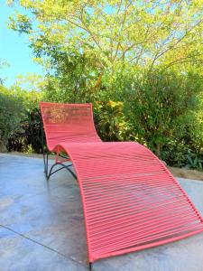 a red bench sitting on top of a sidewalk at Magdalena Beach House in Los Naranjos