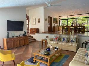 uma sala de estar com um sofá e uma mesa em Casa Bienteveo 15 min de Cuernavaca, 23 personas em Tezoyuca