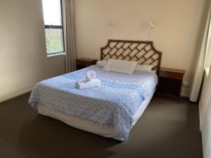 una camera da letto con un letto e un asciugamano sopra di Horizons Unit 2 Beachfront Unit a Bargara