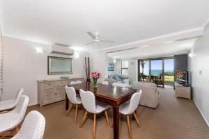 a living room with a dining room table and chairs at Horizons 1 in Bargara +11 photos