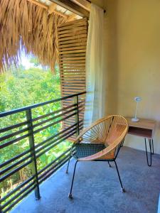 a chair sitting on a balcony with a desk and a window at Magdalena Beach House in Los Naranjos