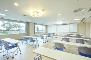 ein Klassenzimmer mit Tischen und Stühlen in einem Klassenzimmer in der Unterkunft KAMENOI HOTEL Oarai in Oarai
