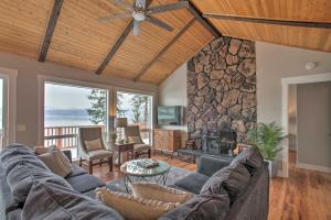 sala de estar con sofá y chimenea de piedra en Hillside Home with Dock about 8 Mi to Coeur dAlene!, en Hayden Lake