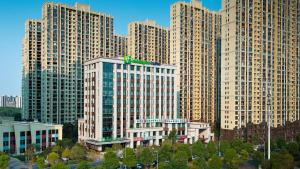 eine Gruppe großer Gebäude in einer Stadt in der Unterkunft Holiday Inn Express Changsha University Tech City, an IHG Hotel in Changsha